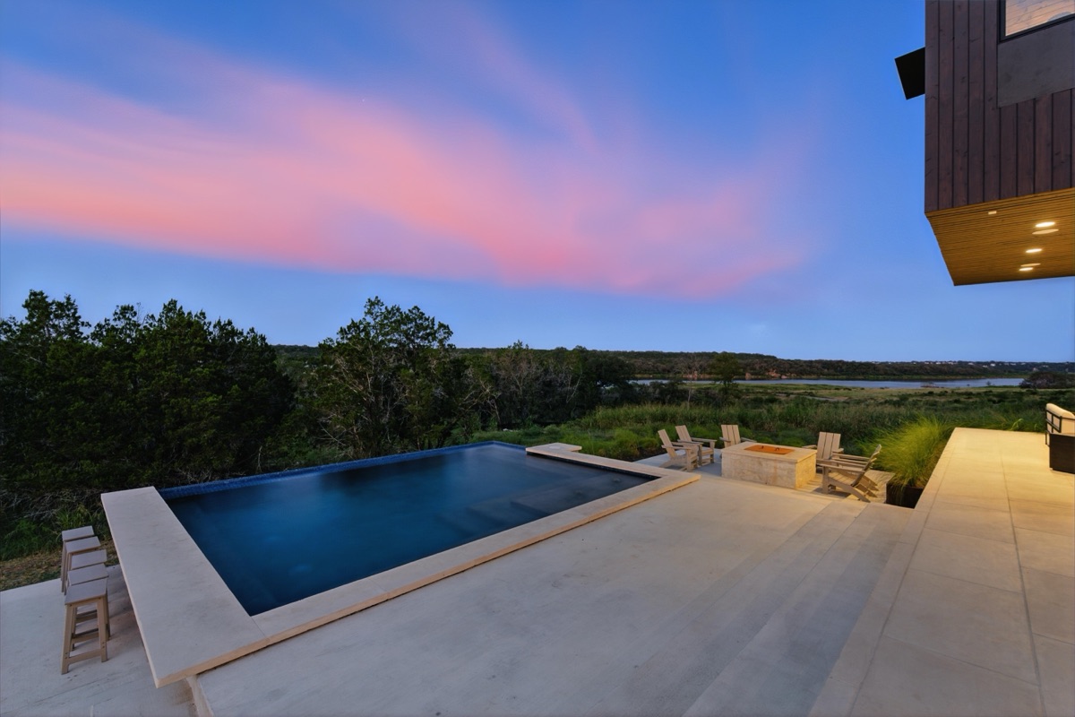 A modern home with an infinity pool at dusk
